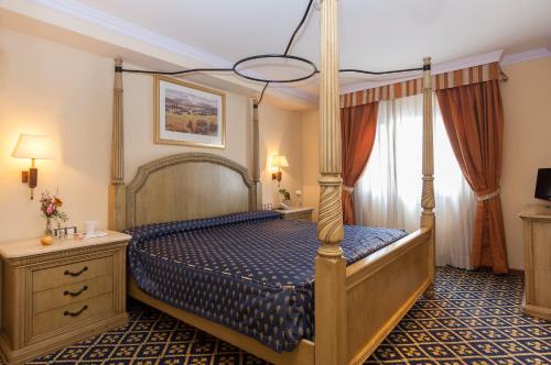 马德里奧地利唐胡安阿果拉酒店的一间卧室设有天蓬床和窗户。