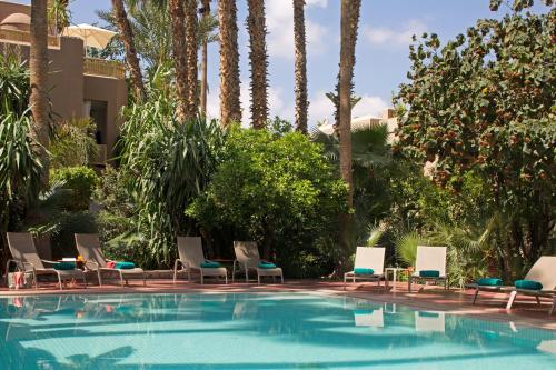 马拉喀什麦地那亚尔丁斯的一个带椅子的游泳池,棕榈树