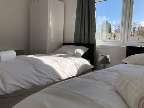 格伦罗西斯Glenrothes Central Apartments - One bedroom Apartment的带窗户的客房内的2张白色床