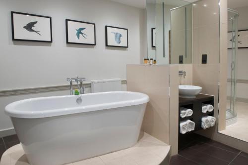 温莎海利校长会议博蒙特庄园酒店的白色的浴室设有浴缸和水槽。