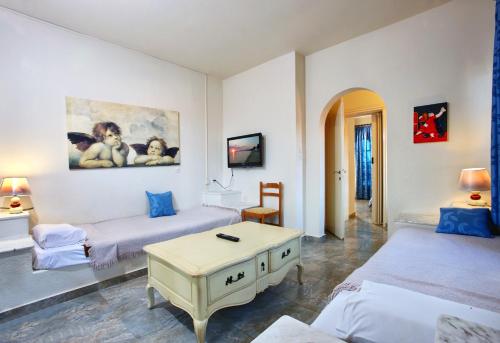 皮加迪卡Assa Maris Beach Hotel的客厅配有两张床和一张桌子