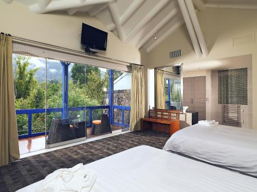 乌鲁班巴阿让洼圣谷疗养酒店的一间卧室设有两张床和大窗户