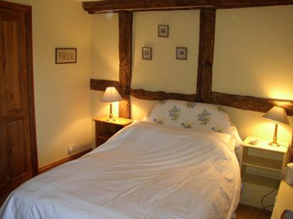 NewnhamGrove Farm B&B的一间卧室配有一张带两盏灯的大型白色床。
