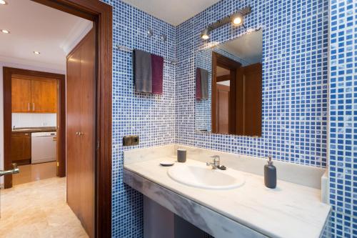洛斯克里斯蒂亚诺斯El Ancla的蓝色瓷砖浴室设有水槽和镜子