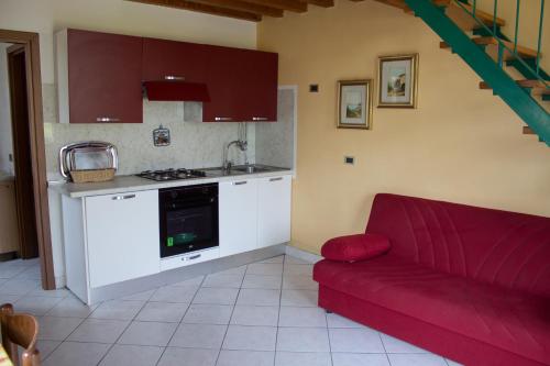 Ponte CaffaroCasa Ornella的一间带红色沙发的客厅和一间厨房