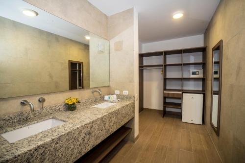 伊察拉斯登纳斯酒店的一间带两个盥洗盆和大镜子的浴室