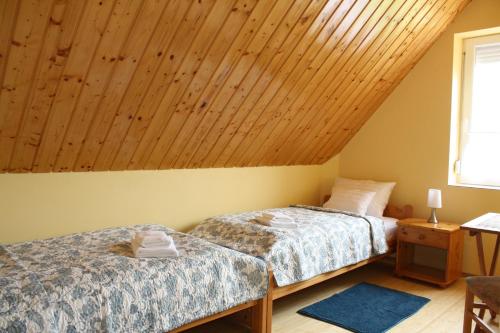 米什科尔茨道波曹Kedvenc Vendégház的配有木天花板的客房内的两张床