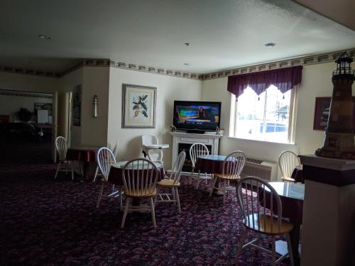新奥尔良市灯塔酒店的一间带桌椅和电视的用餐室