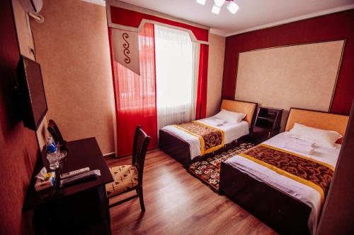 奥什Asman Guest House的酒店客房配有两张床和一张书桌