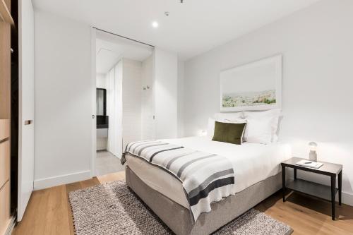 墨尔本泰尔阿尔伯特公园湖公寓的白色的卧室设有一张大床和一个窗户