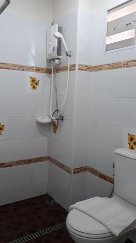 春蓬春蓬旅游酒店的浴室配有白色卫生间和盥洗盆。