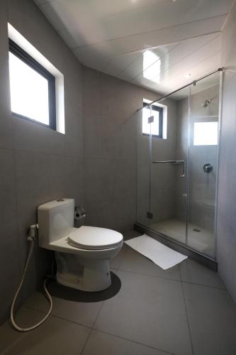 马尼拉马卡蒂U酒店的一间带卫生间和玻璃淋浴间的浴室