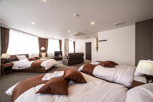 函馆斯特拉共管式公寓的酒店客房,设有三张床和椅子