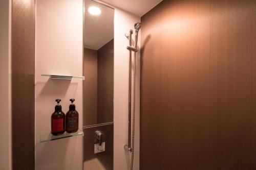 花卷市预感酒店的浴室设有淋浴,架子上装有两瓶水