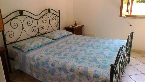 莱乌卡Villa i Pini Santa Maria di Leuca的一间卧室配有一张带花卉床罩的床