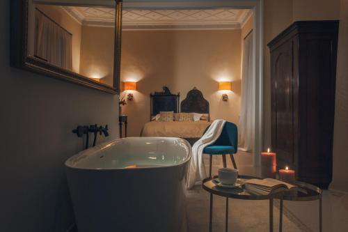锡拉库扎阿基米德旅馆的带浴缸的浴室和1间带1张床的卧室