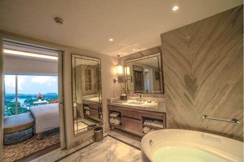 班加罗尔班加罗尔泰姬MG路酒店的带浴缸、水槽和镜子的浴室