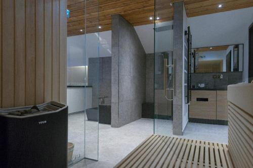 毛特Gasthaus - Hotel FUCHS的一间位于客房内的玻璃淋浴间的浴室