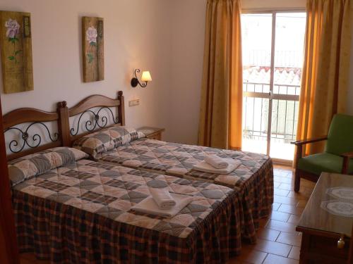 内尔哈卡萨诺瓦公寓酒店的一间卧室配有一张带桌子和窗户的床