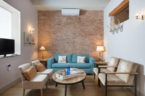 巴塞罗那BCN兰布拉加泰罗尼亚公寓的客厅配有蓝色的沙发和椅子