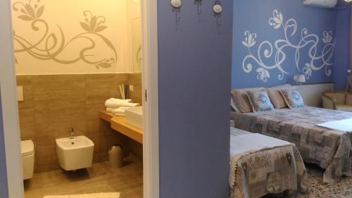 贾迪尼-纳克索斯B&B Villa Raineri的客房内的浴室设有两张床和一个盥洗盆。