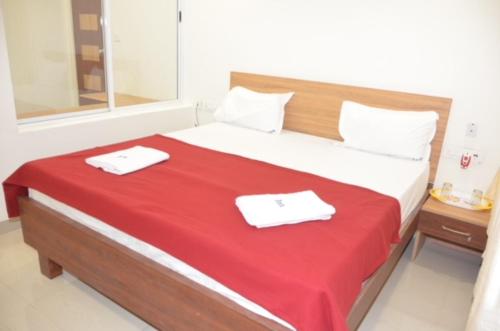 库姆巴科纳姆Raya's Inn的一间卧室配有一张大床和两条毛巾