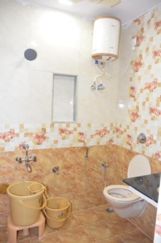 库姆巴科纳姆Raya's Inn的浴室设有卫生间和水桶