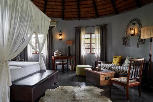 提姆巴瓦提禁猎区Motswari Private Game Reserve by NEWMARK的一间卧室设有一张床和一间客厅。