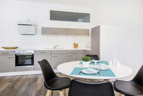 阿尔布斯塔特Apartments by Intermezzo的厨房配有白色的桌子和黑色的椅子