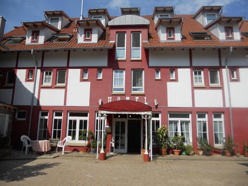 辛斯海姆赫希跨国酒店的一座红色和白色的大建筑,设有庭院