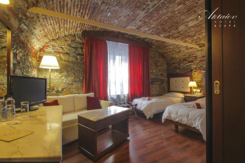 埃尔莫波利斯Hotel Aktaion Syros的客厅配有两张床、一张沙发和一台电视