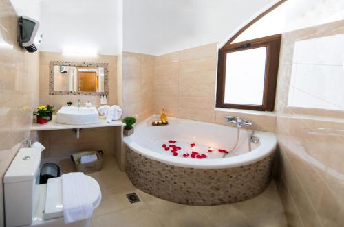 罗德镇Emerald Dream House的浴室设有浴缸,上面装有红色鲜花