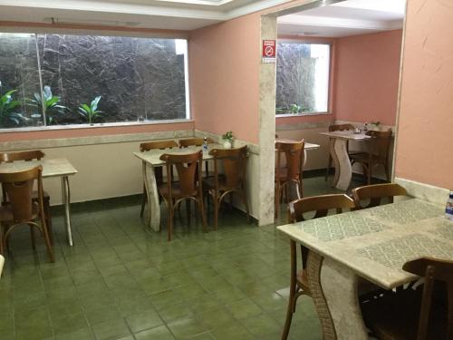 马塞约Hotel Porto Grande的餐厅设有桌椅和窗户。