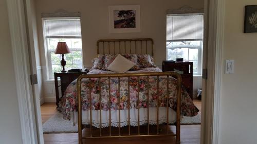 Myrtle CreekCharming, Private Cottage in Myrtle Creek的一间卧室配有一张带花卉床罩和窗户的床。