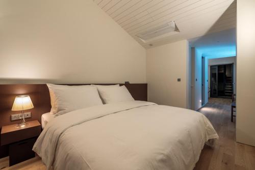 仁川市Hotel 498的卧室配有白色大床和灯
