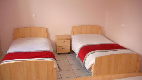 拉纳斯Auberge De Peyrebeille的两张睡床彼此相邻,位于一个房间里