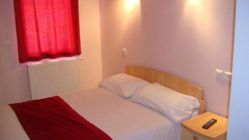 拉纳斯Auberge De Peyrebeille的一间卧室配有一张红色窗户的床