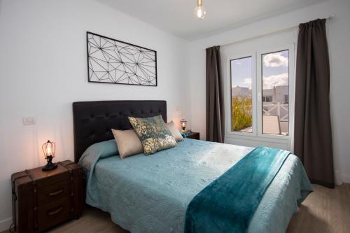 宏达海滩Flower Beach Lanzarote的一间卧室设有一张大床和一个窗户。