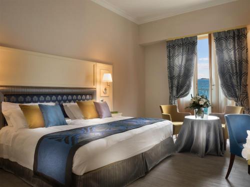 加尔多内-里维耶拉加尔多内大酒店的酒店客房设有一张大床和一张桌子。