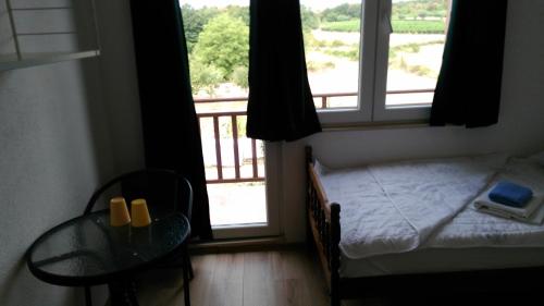 默主歌耶伊万卡巴拉克膳食公寓的一间卧室配有一张床、一张桌子和一个窗户。