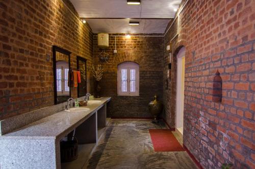 GarliNaurang Yatri Niwas的一间带两个水槽和砖墙的浴室