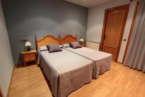 厄尔·彭特·德·苏尔特艾尔佩德里斯酒店的一间卧室配有一张大床和木制床头板