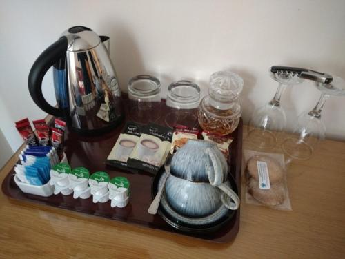 阿勒浦Ardlair Guest House的茶壶和其他物品的托盘