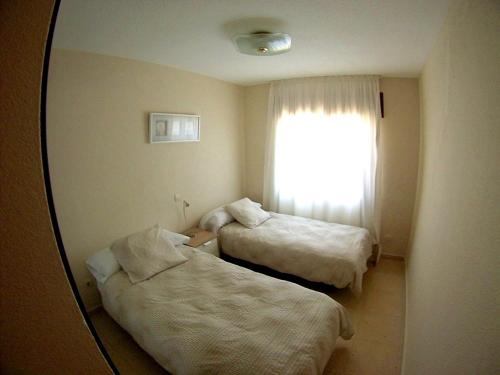 马拉加Villa Buenavista的酒店客房,设有两张床和镜子