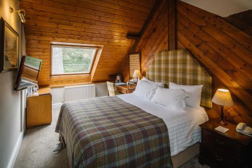 鲍内斯温德米尔林德霍伊酒店的木制客房内的一间卧室配有一张大床