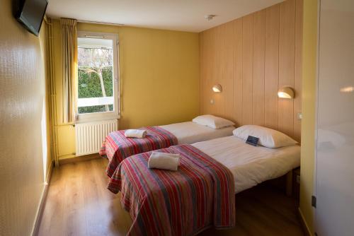 塞诺德阿讷西法斯特酒店的酒店客房设有两张床和窗户。
