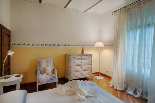 卡斯泰尔菲奥伦蒂诺Tenuta Cambiano by PosarelliVillas的一间卧室配有一张床、梳妆台和婴儿床。