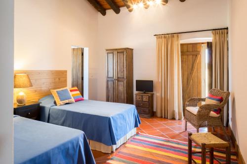 坎普马约尔Monte Alto Agroturismo的一间卧室配有两张床、一把椅子和电视