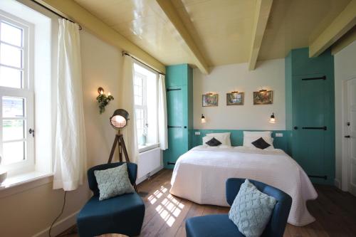 德文格洛B&B Lhee-Gaarde的一间卧室配有一张床和两张蓝色椅子