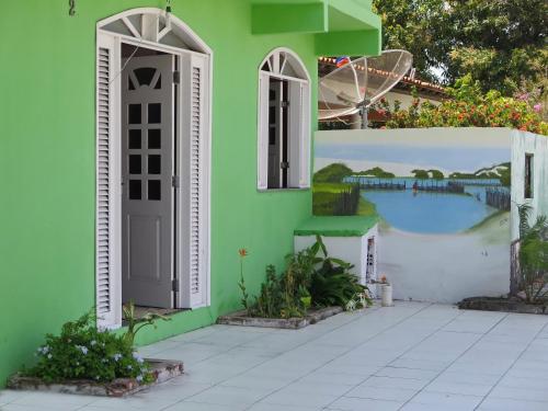 圣阿马鲁Pousada Rio Alegre的一座带门和壁画的绿色房子